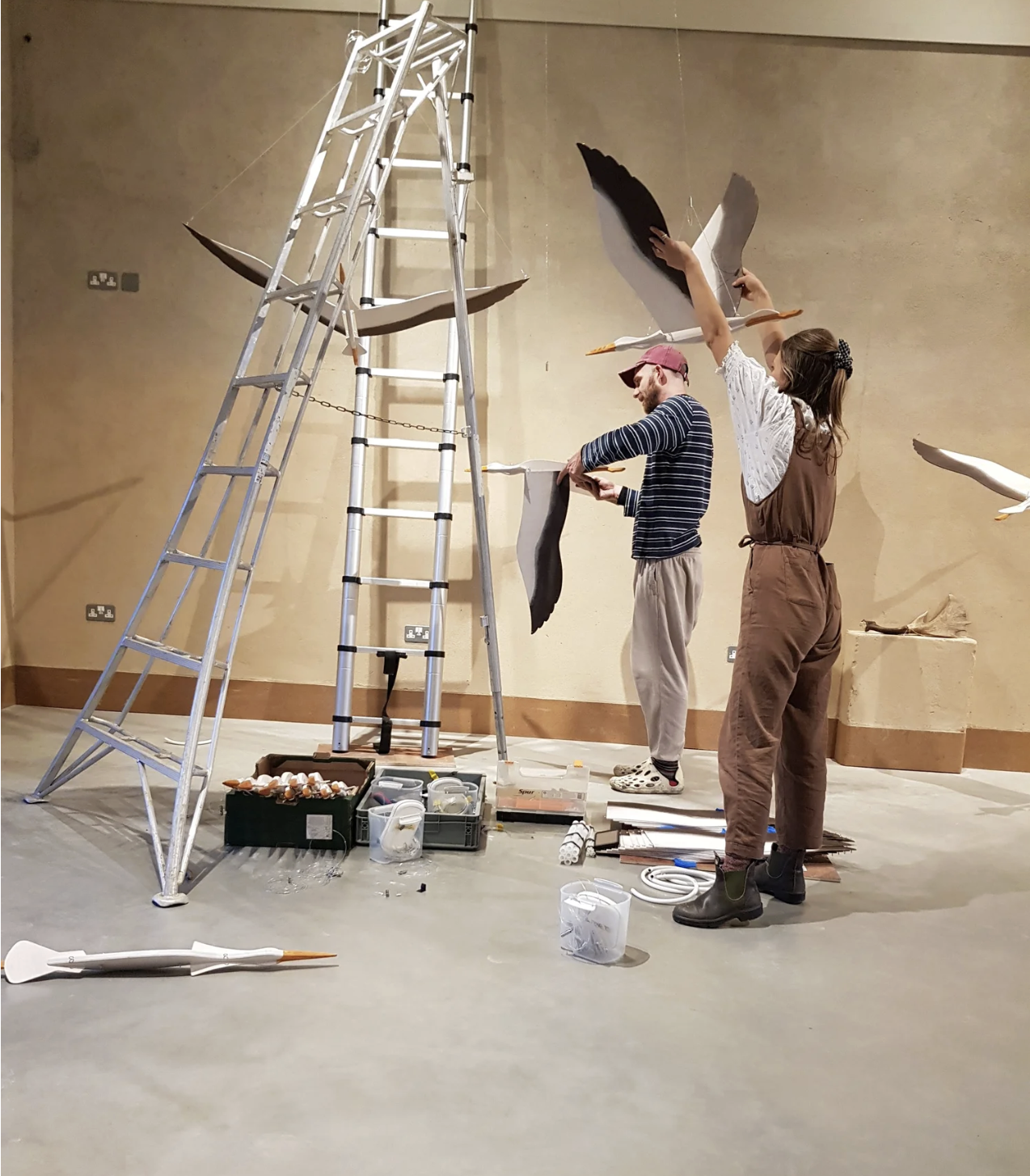 Assembling stork mobiles using a tripod pruning ladder