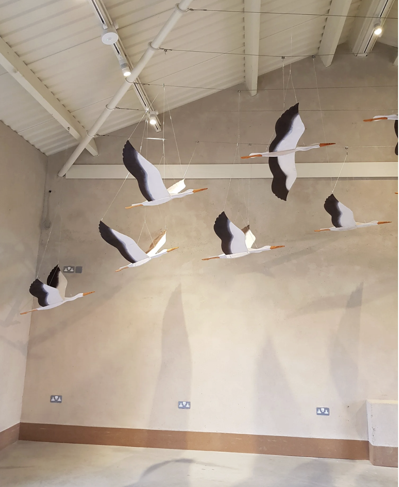Finished flock of stork mobiles suspended on invisible line