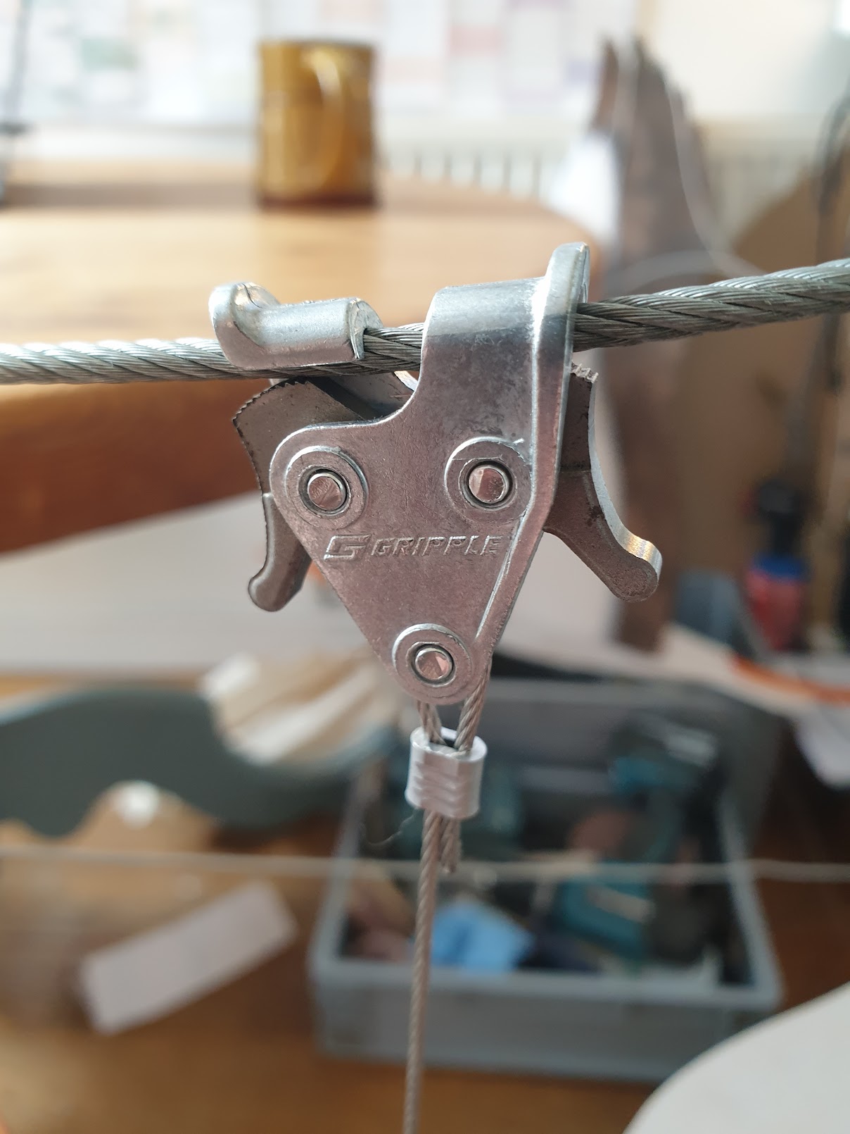 Gripple C-Clip clamped on a catenary wire with a drop cable hanging vertically